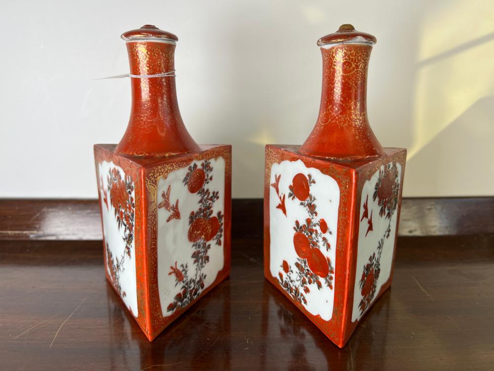 Pair of Japanese Kutani porcelain triangle-section sake bottles and stoppers, iron red and gilt with birds and flowers, Meiji period, circa 1880-1910