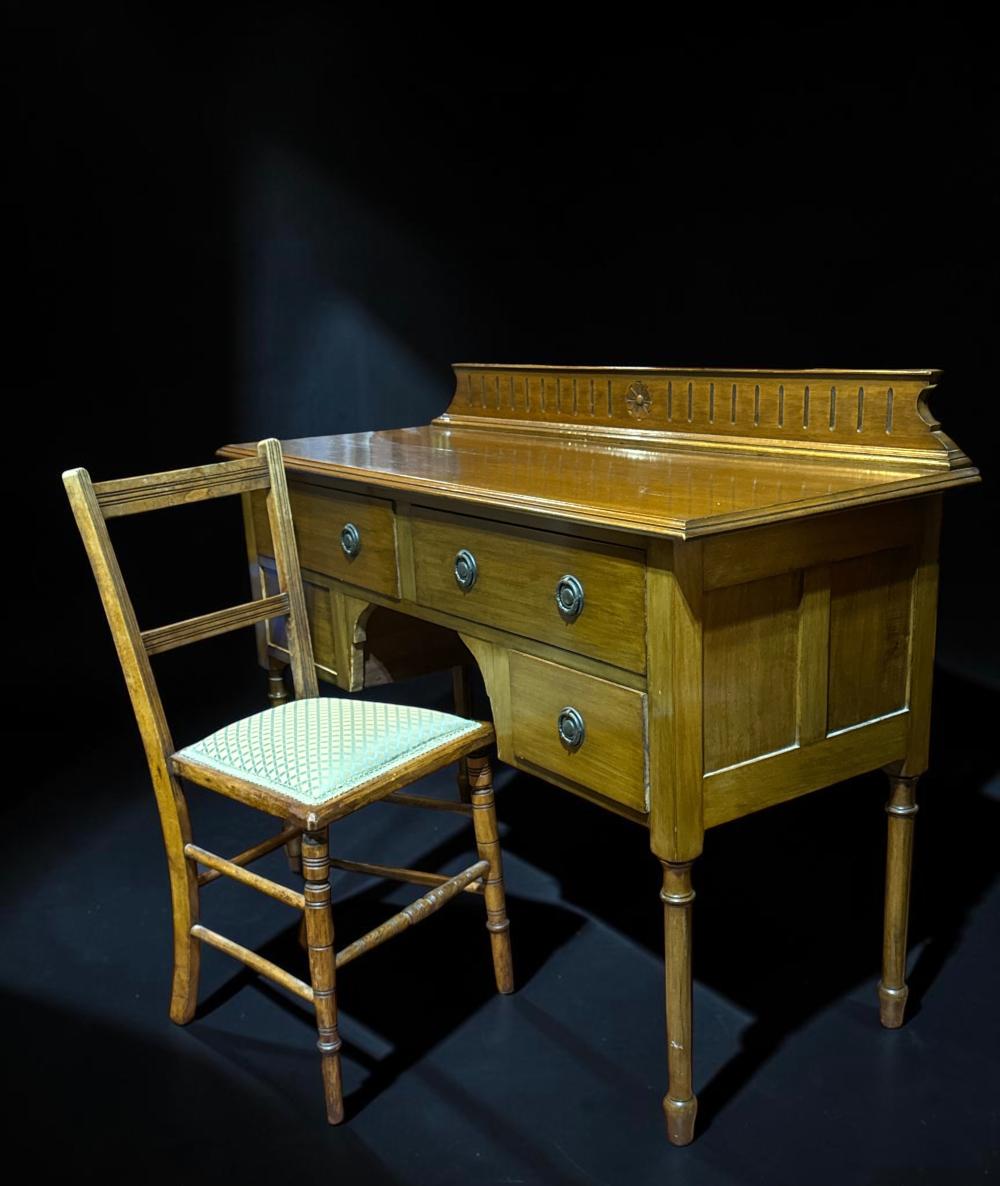 Faded Blackwood kneehole writing desk with pierced gallery back, together with a matched  side chair, circa 1900-1910