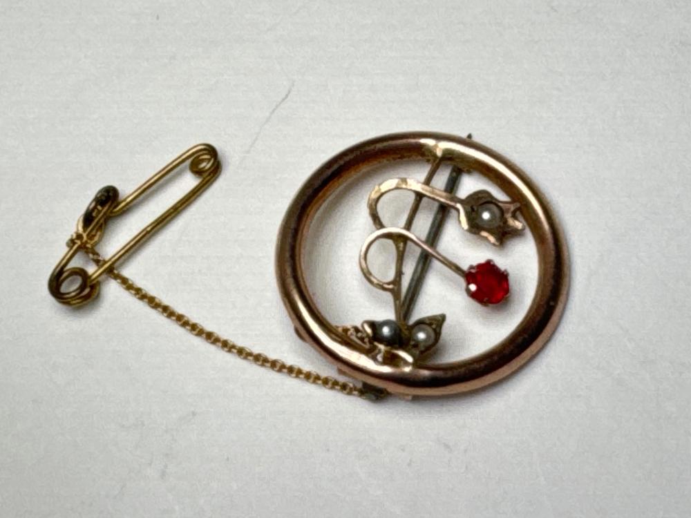 9ct rose gold open-circle brooch set with seed pearls and red paste stone, with safety chain, circa 1900-1910