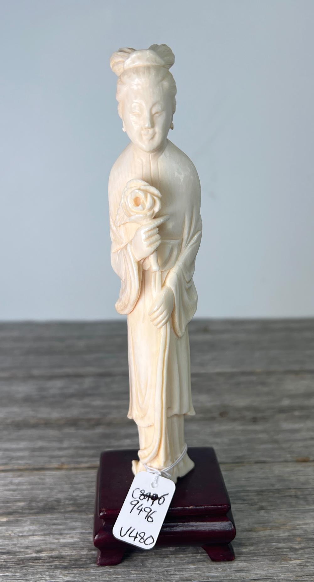 Carved ivory figure of a lady holding flowers, earlier 20th century
